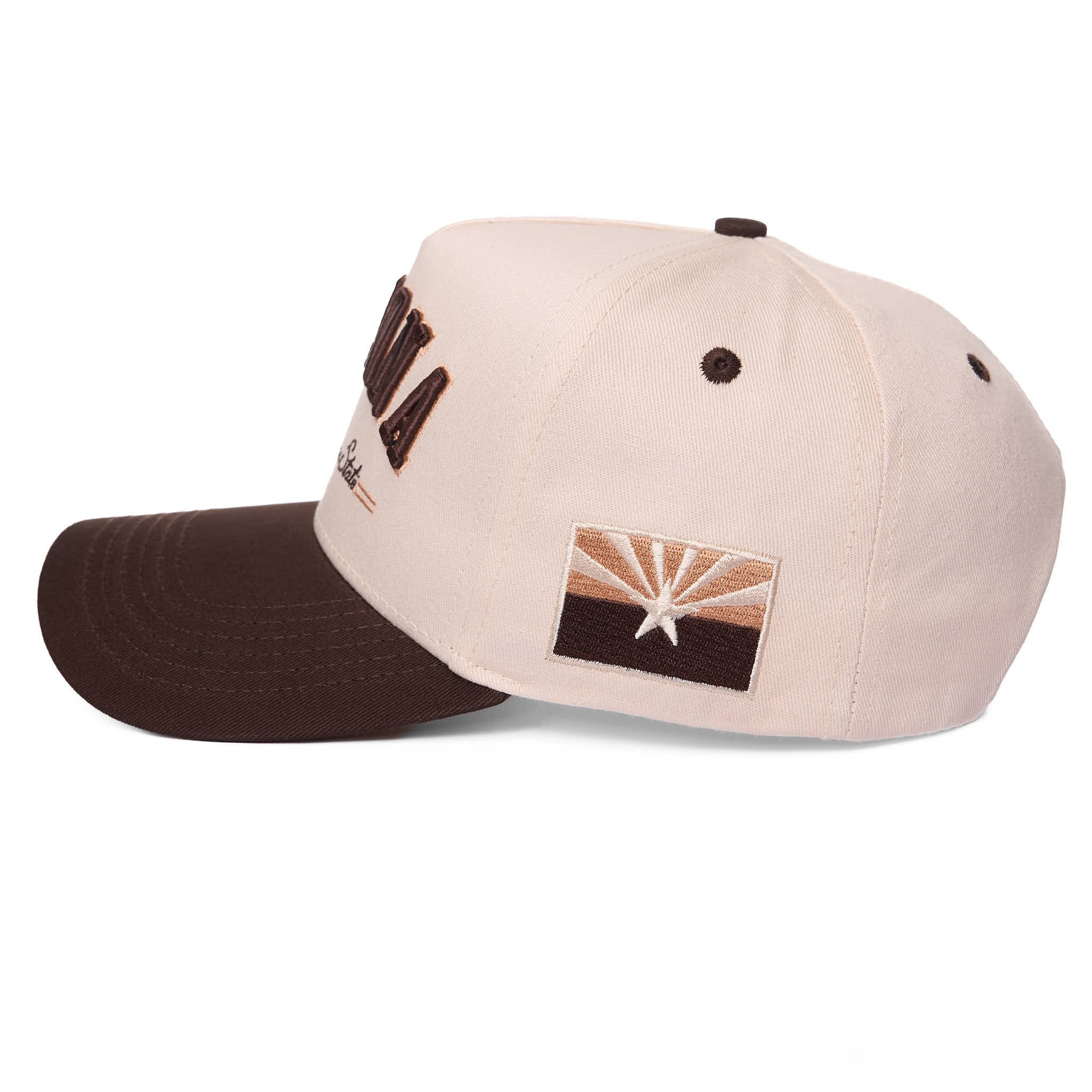 Beige and brown cap with embroidered design on a white background