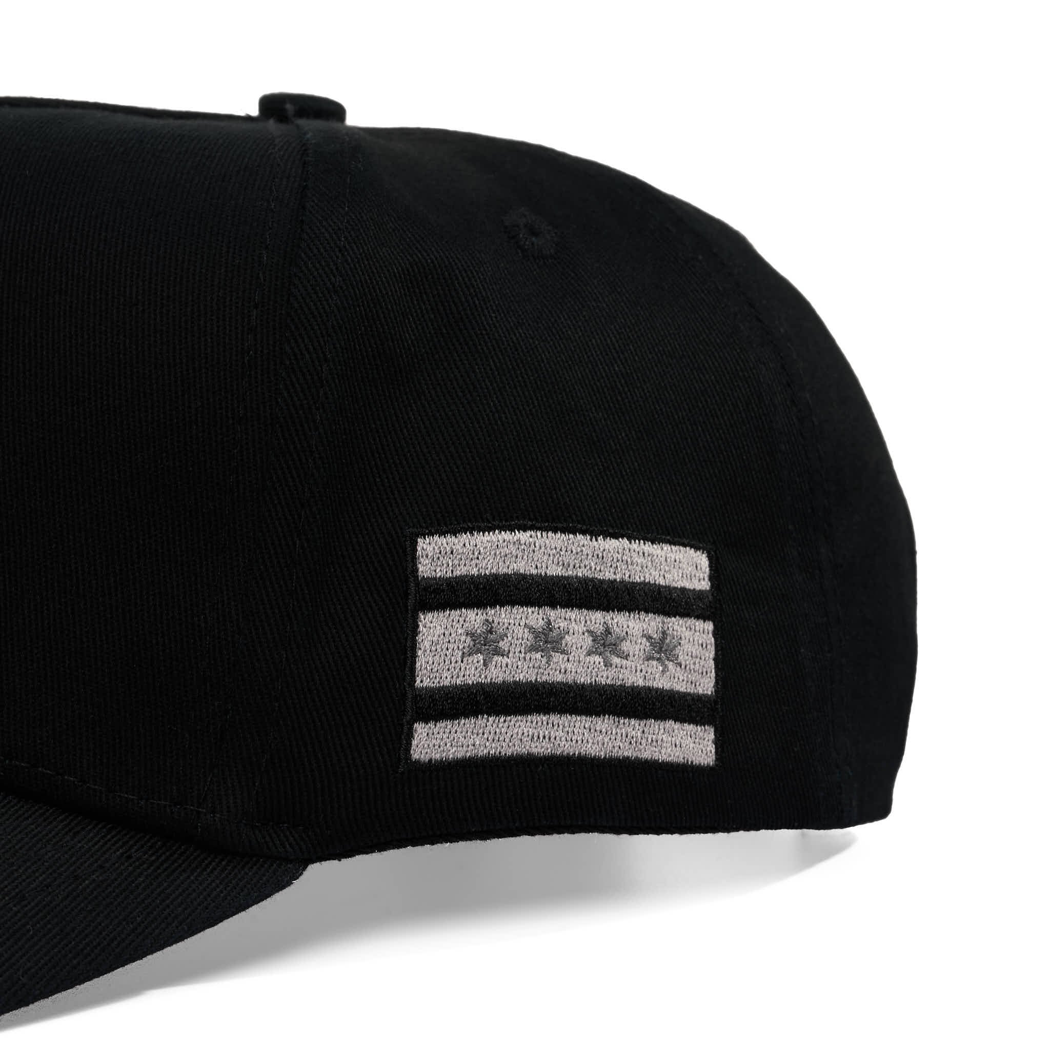 Black cap with gray embroidered design on a white background