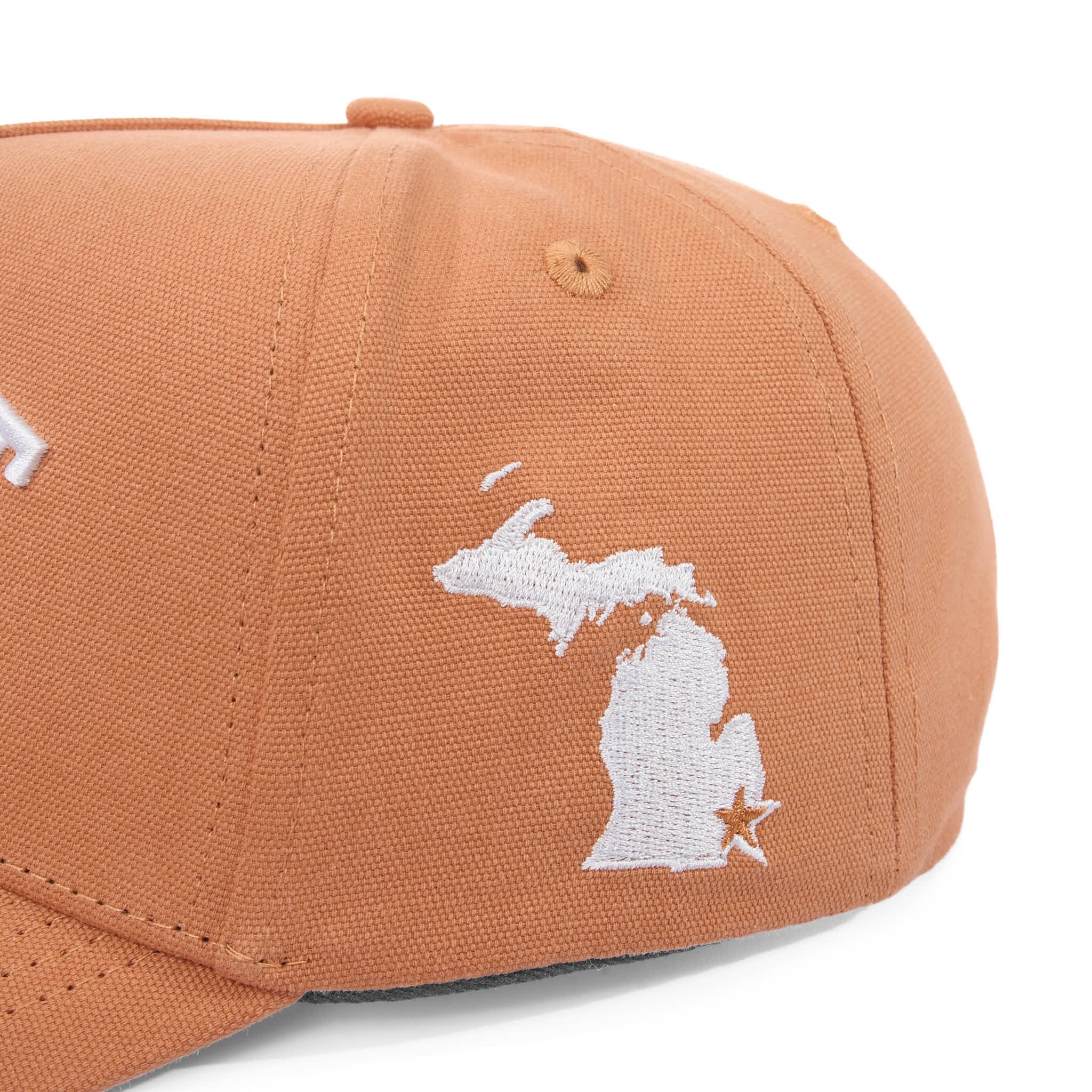 Brown cap with white embroidered design on a white background
