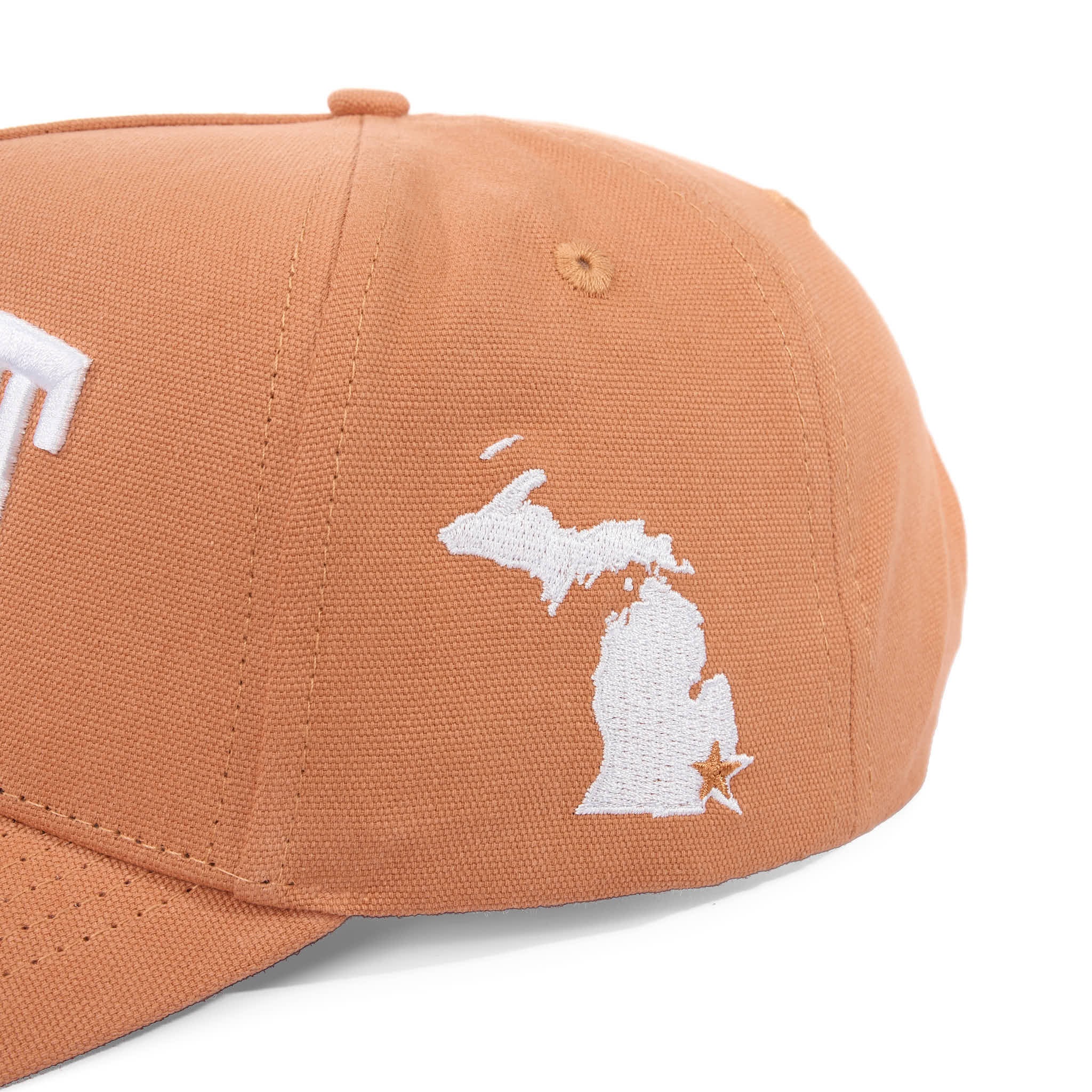 Brown cap with white embroidered design on a white background