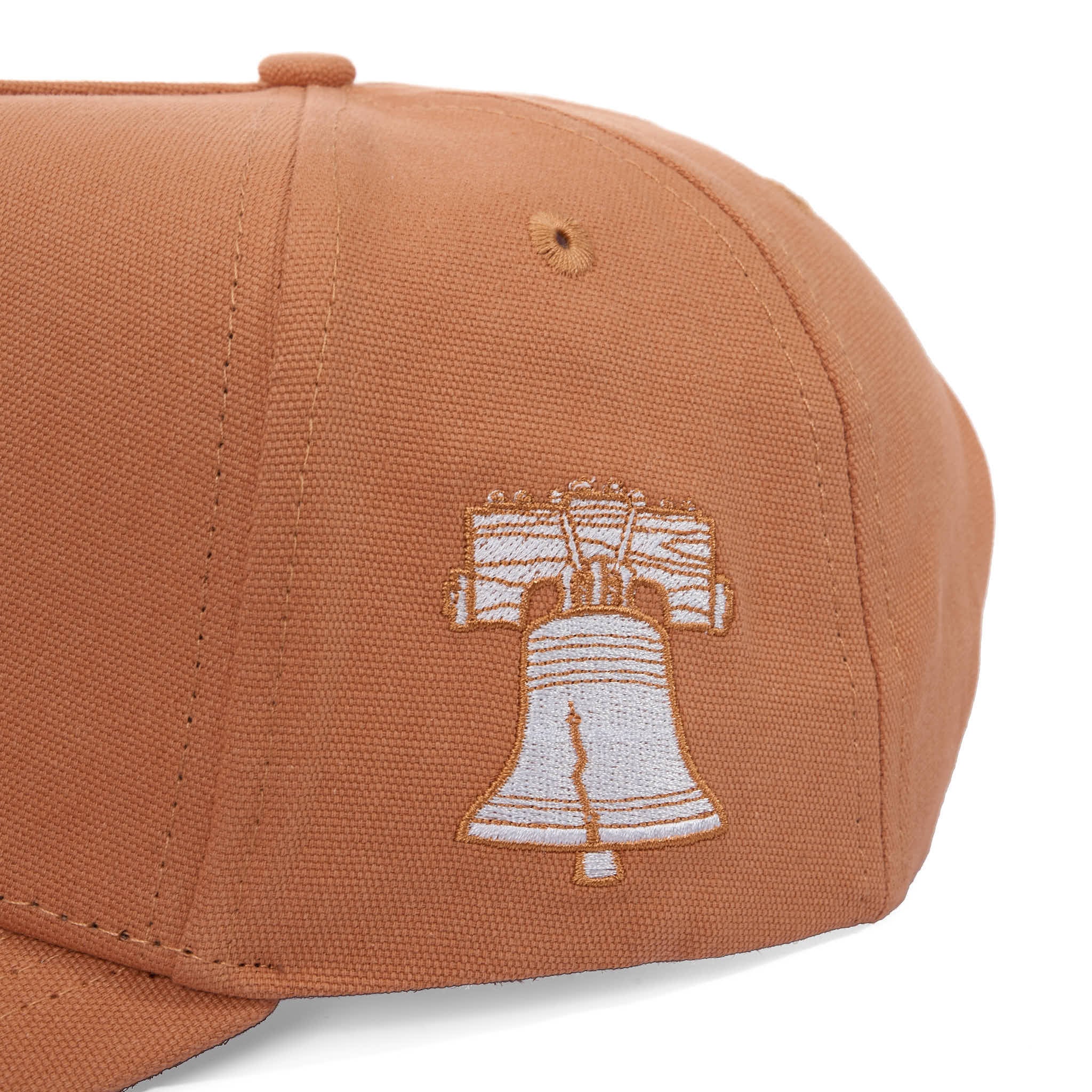 Brown cap with a white embroidered design on a white background