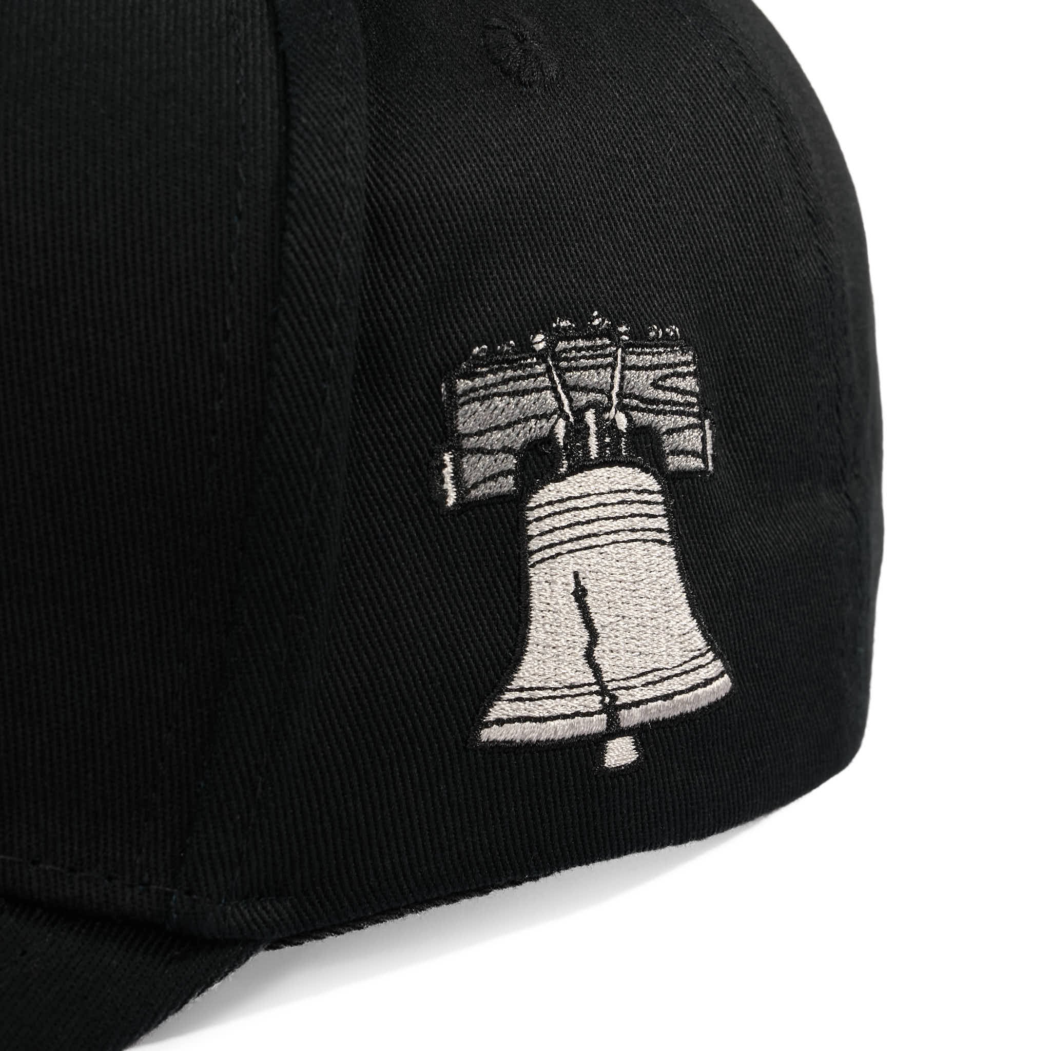 Black cap with a white Liberty Bell emblem on a white background