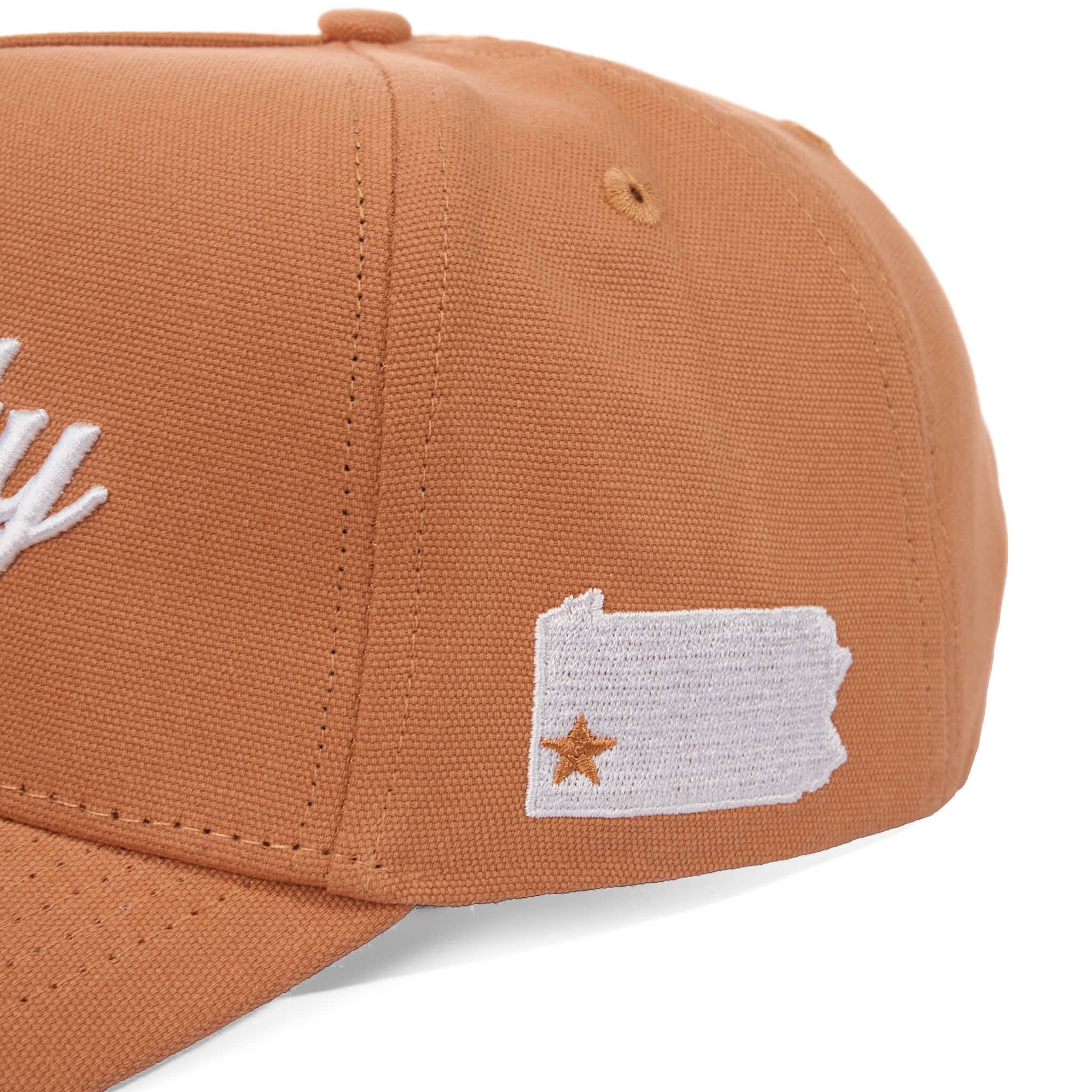 Brown cap with a white embroidered design on a white background