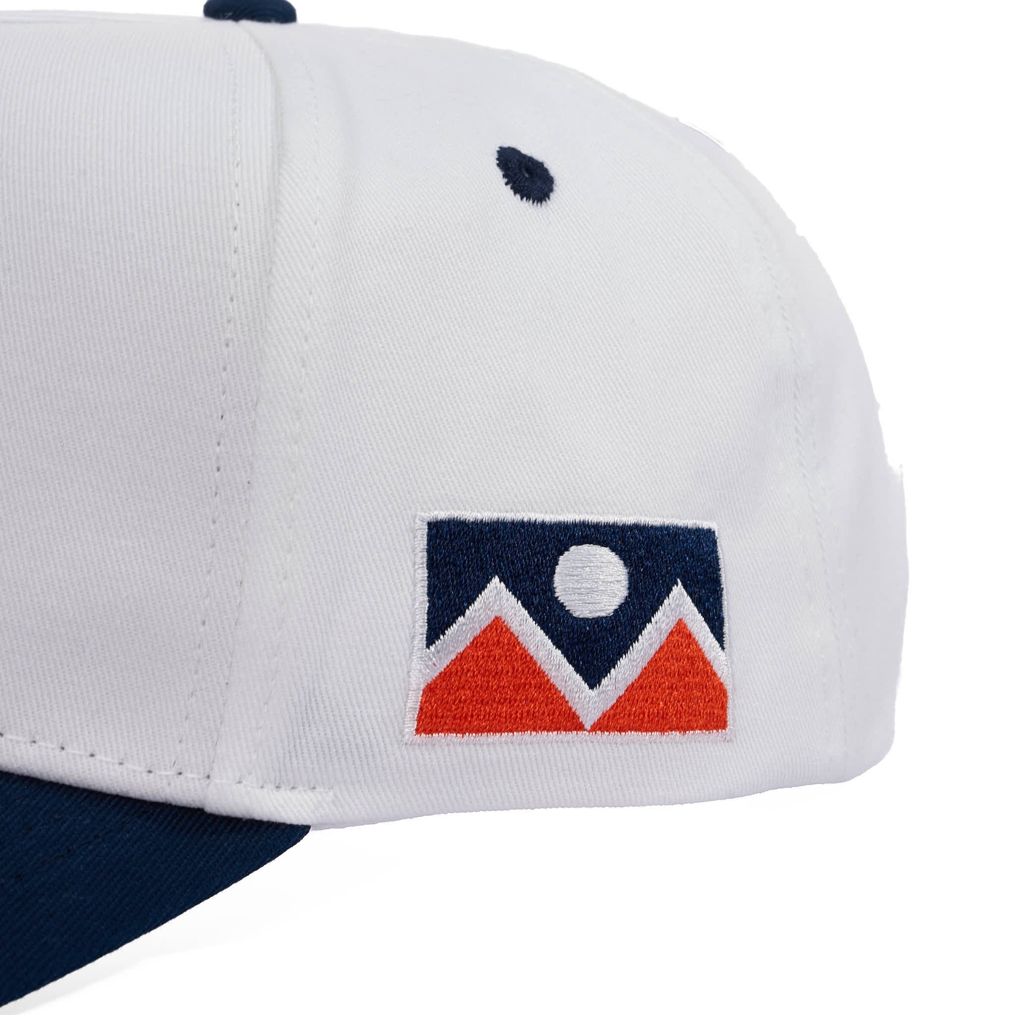 Close-up of a cap with a flag featuring mountains on a white background
